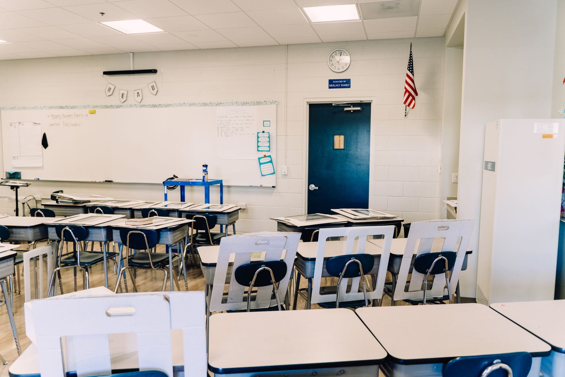 Pusta, jasna klasa z ławkami, tablicą i flagą USA