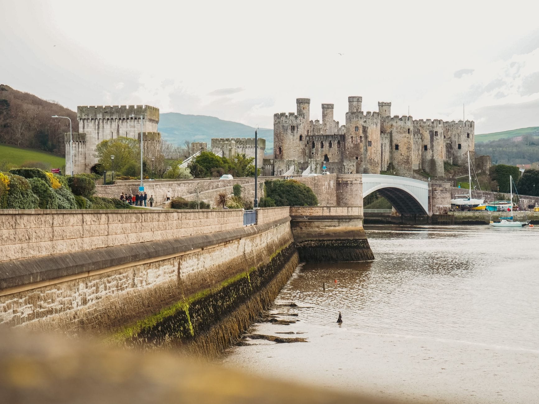 Zamek Conwy nad rzeką na tle zielonego krajobrazu Walii