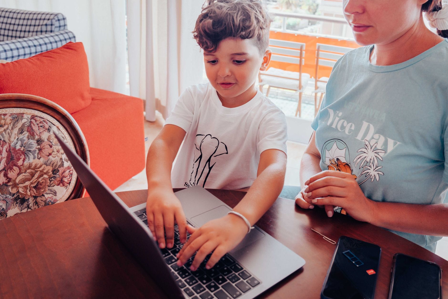 Mama z dzieckiem przy stole korzystają z laptopa w domu Mama z dzieckiem przy stole korzystają z laptopa w domu