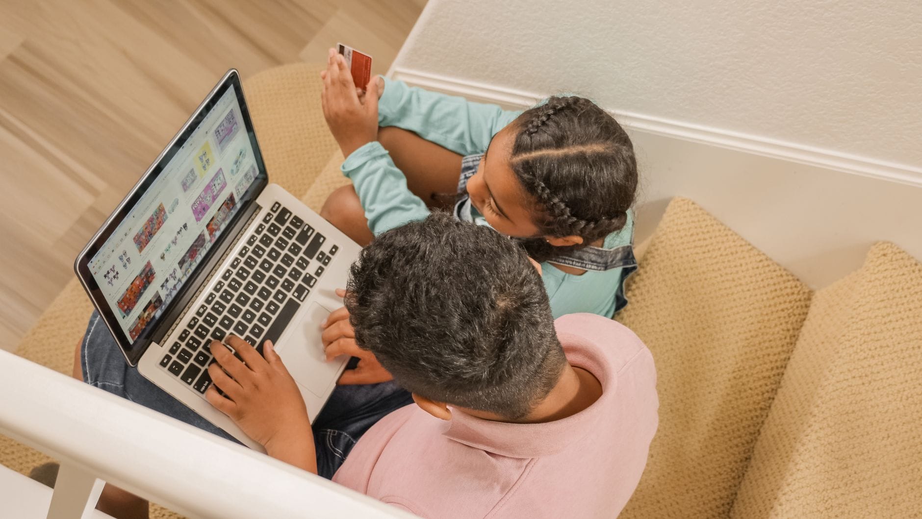 Ojciec z córką na schodach robią wspólne zakupy online na laptopie